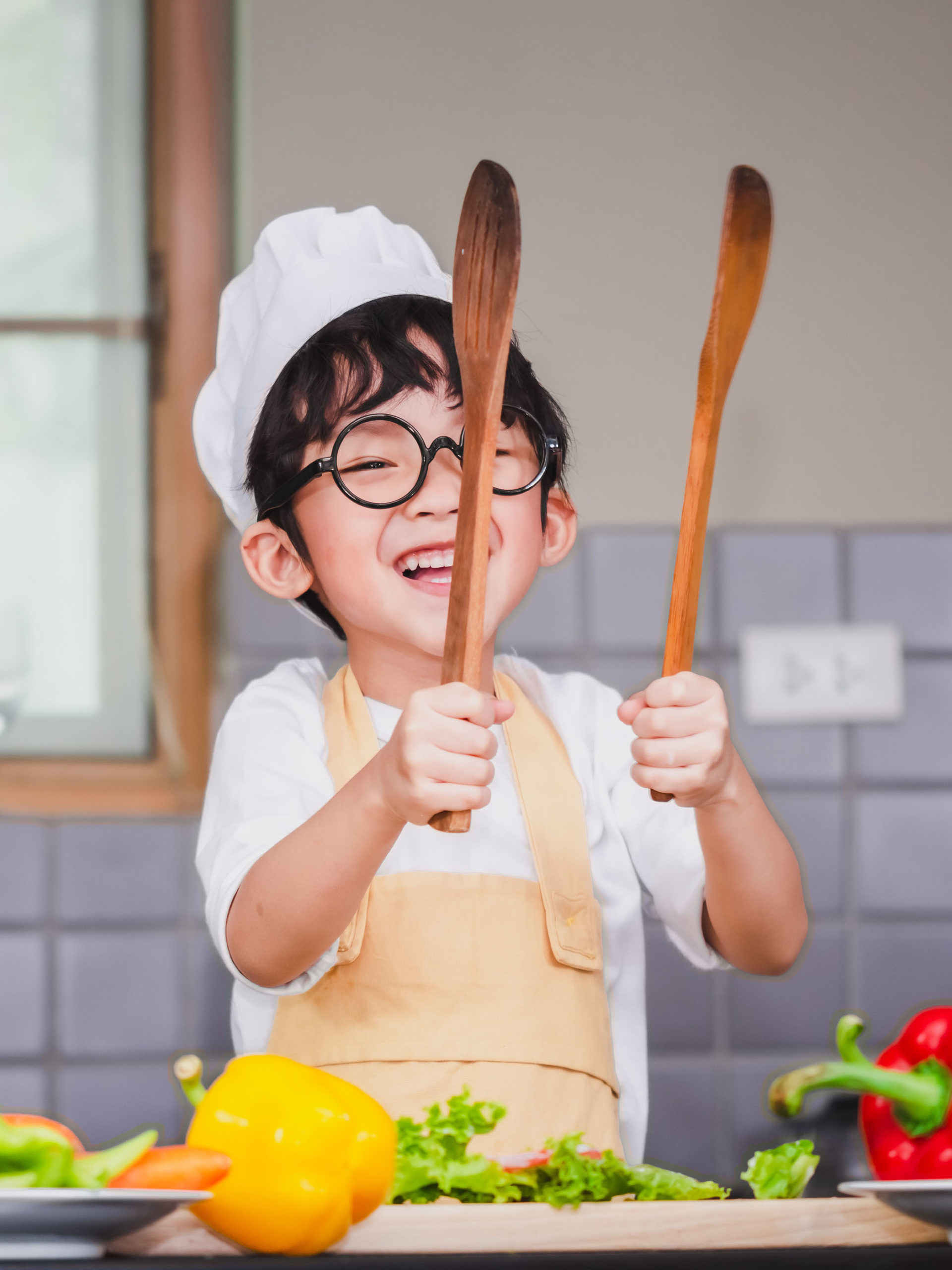 young boy having fun making a salad