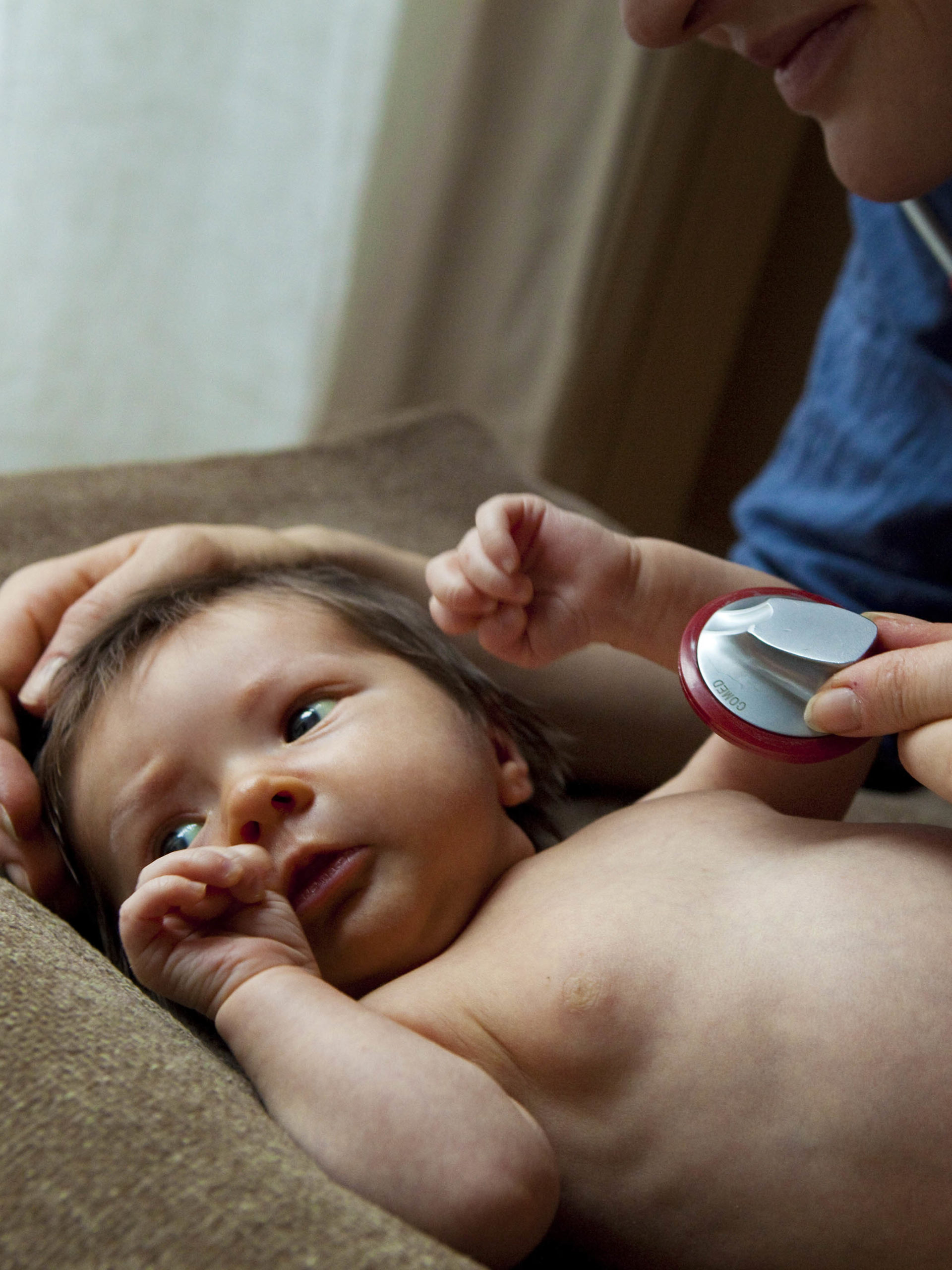 newborn being examined by pediatrician at appointment