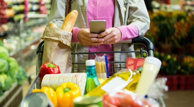 Mom with grocerie cart full of bread, veggies and other food