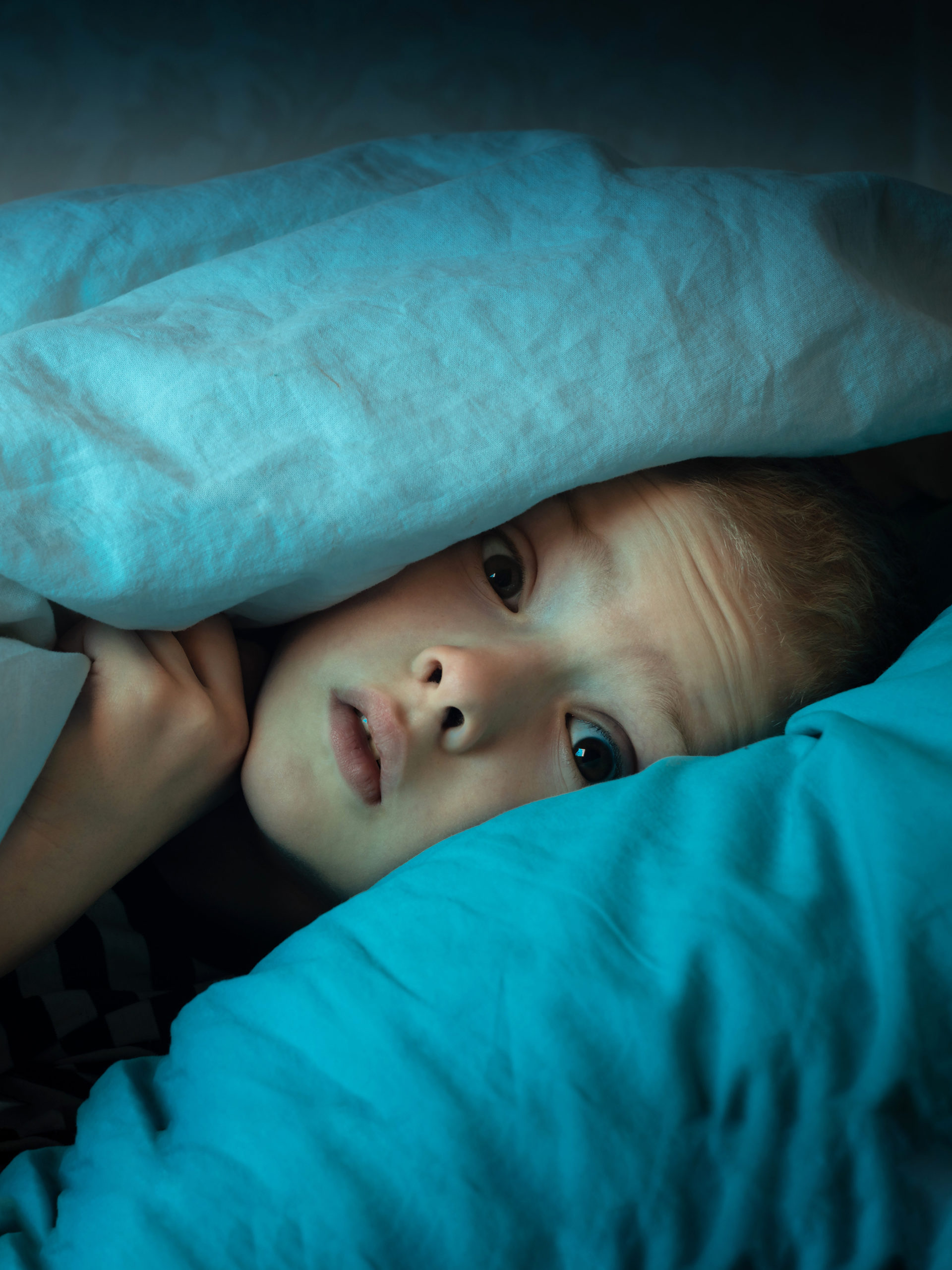 scared child nightmares hiding in between pillows