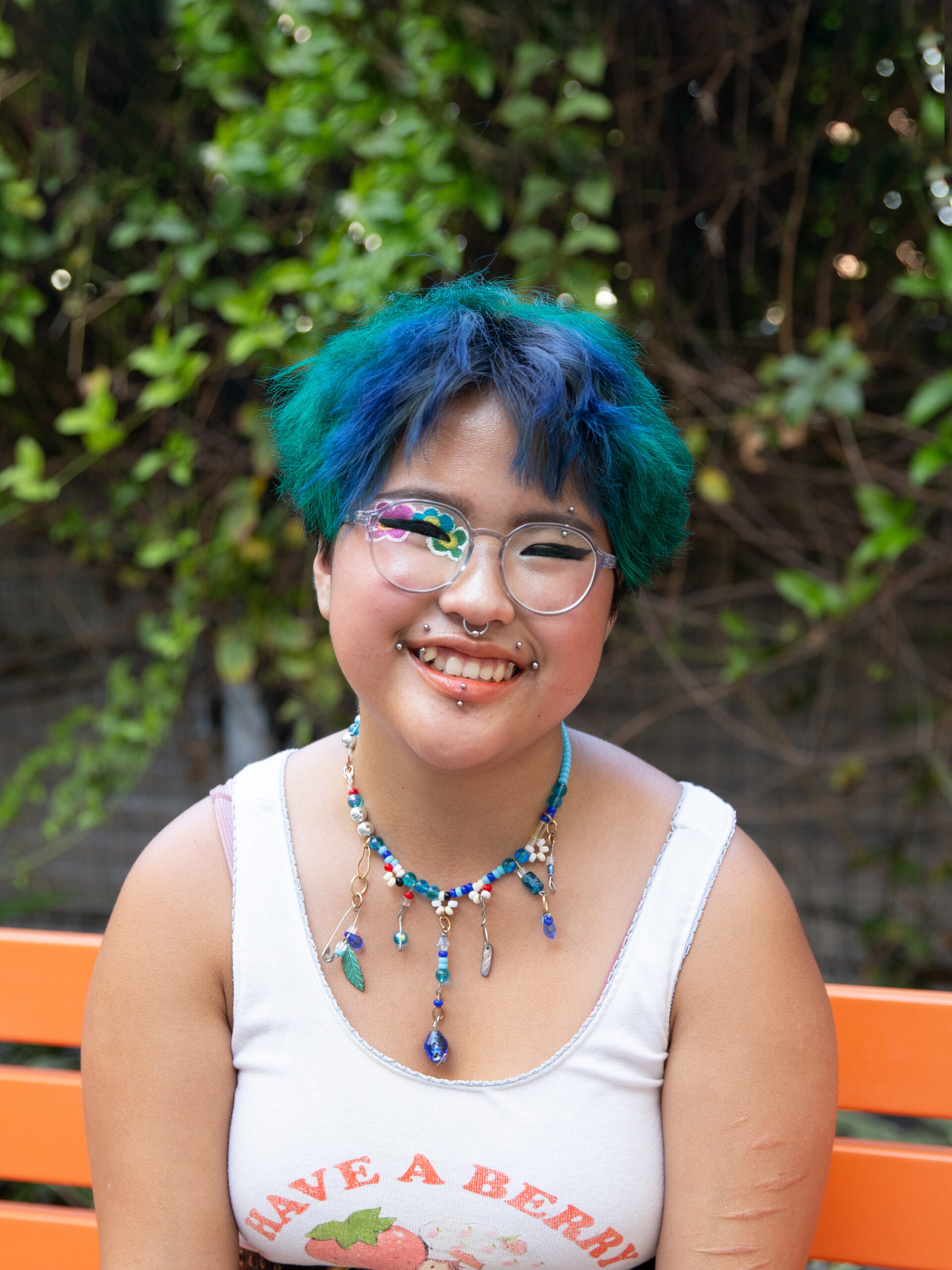 Portrait of joy smiling while sitting on an orange bench